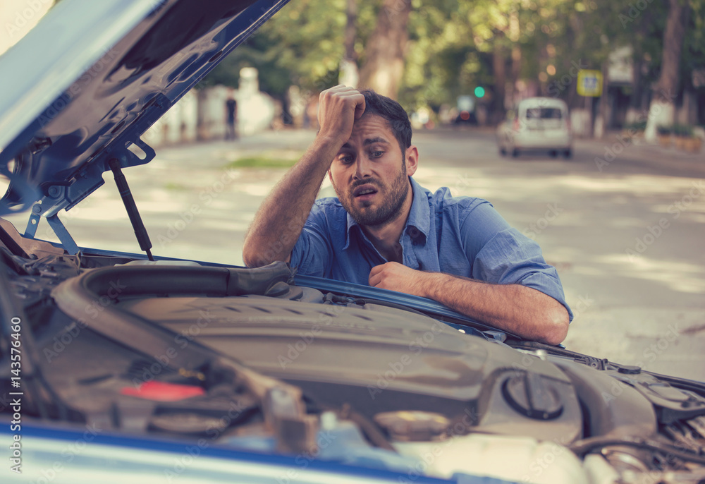 © pathdoc - stressed man having trouble with broken car looking in frustration at failed engine