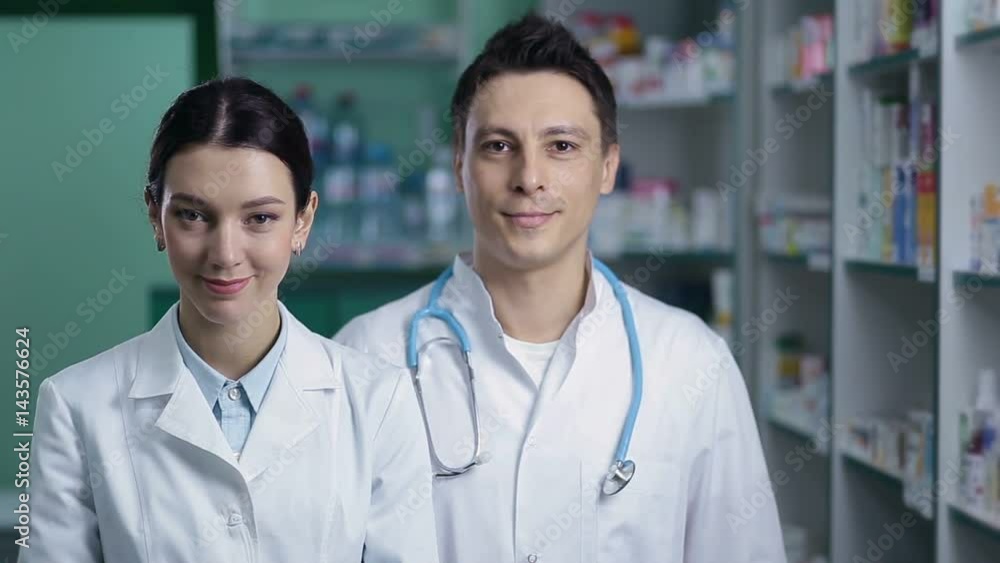 Smiling friendly pharmacists working in pharmacy Smiling friendly pharmacists working in pharmacy