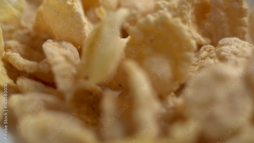 Corn flakes falling in white bowl in slow motion. Close up macro view Corn flakes falling in white bowl in slow motion. Close up macro view
