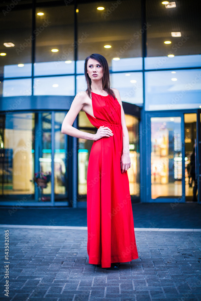 model in red dress posing at the modern building model in red dress posing at the modern building