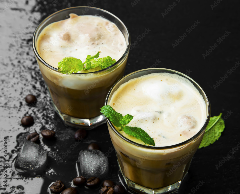 Ice coffee glasses with ice cubes and froth, mint leaves decor Ice coffee glasses with ice cubes and froth, mint leaves decor