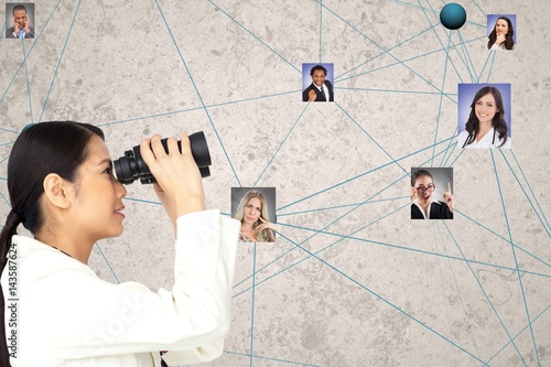 Businesswoman looking at candidates through binoculars photo