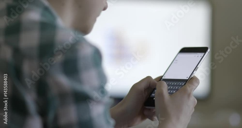 Young woman texting, using smartphone in office, slow motion