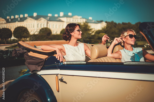Two stylish ladies in a classic convertible © Nejron Photo