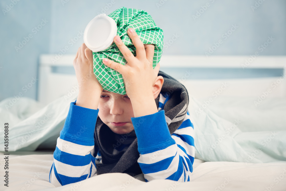 Ill boy lying in bed. sad child with fever and ice bag on head Stock Photo  | Adobe Stock