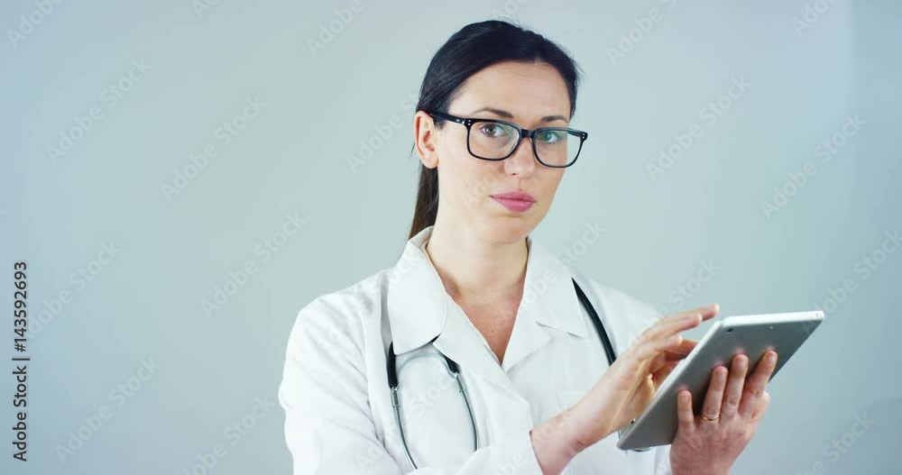 Portrait of a female doctor with white coat and tablet and stethoscope smiling looking into camera on white background. Concept: doctor, health care, love of medicine. Portrait of a female doctor with white coat and tablet and stethoscope smiling looking into camera on white background. Concept: doctor, health care, love of medicine.