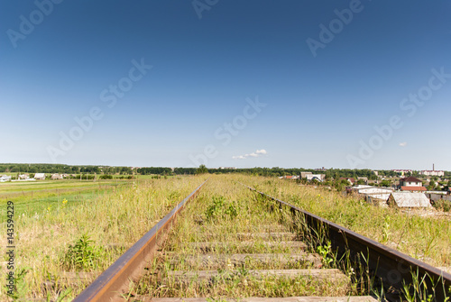 Rails in the grass against the sky 