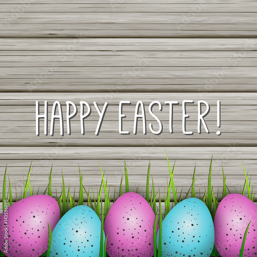 Happy Easter Greeting Card. Colorful Eggs and Green Grass on Wooden Background