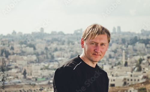 Молодой мужчина на фоне городской панорамы Иерусалима, Израиль photo