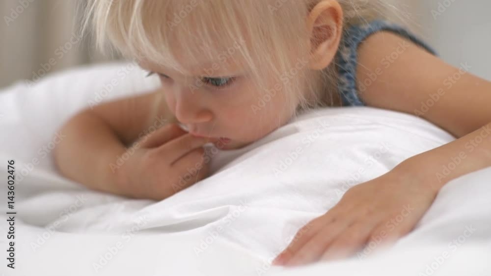 Little girl lying on the bed and playing games on smartphone slow motion Little girl lying on the bed and playing games on smartphone slow motion
