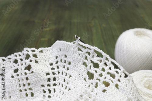 White vintage elements of Irish crochet. Cotton yarn for knitting, crochet hook. Crochet doilies and crochet pattern coasters