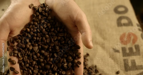 High quality hand dropping a handful of coffee beans, slow motion 4k
