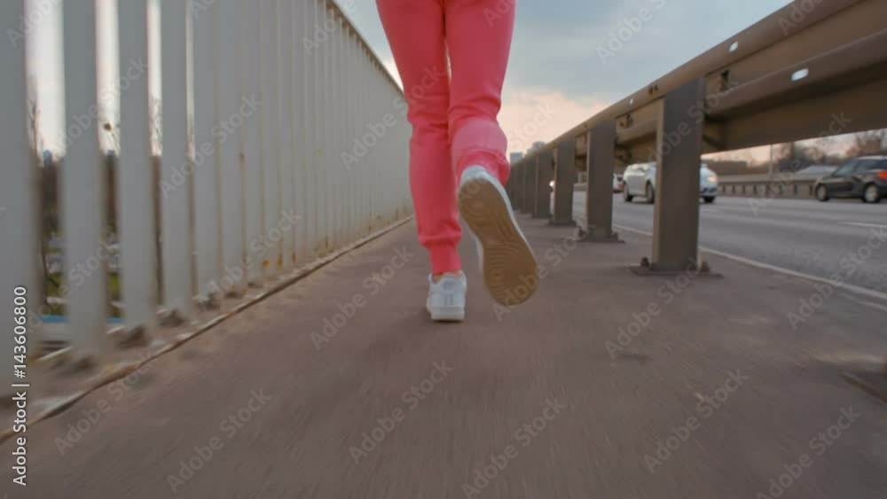 Slow Motion of Nice Young Woman in Sportswear Running on a Bridge in the City. Female jogging back view CloseUp Slow Motion of Nice Young Woman in Sportswear Running on a Bridge in the City. Female jogging back view CloseUp