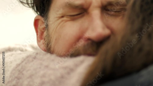 Sad man in love hugging girlfriend crying slow motion closeup at sunset