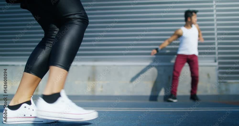 Low angle view of young urban street dancers dancing in urban environment Low angle view of young urban street dancers dancing in urban environment