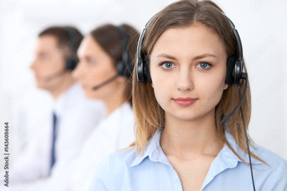 Call center operators. Focus at young beautiful business woman in headset. Call center operators. Focus at young beautiful business woman in headset.