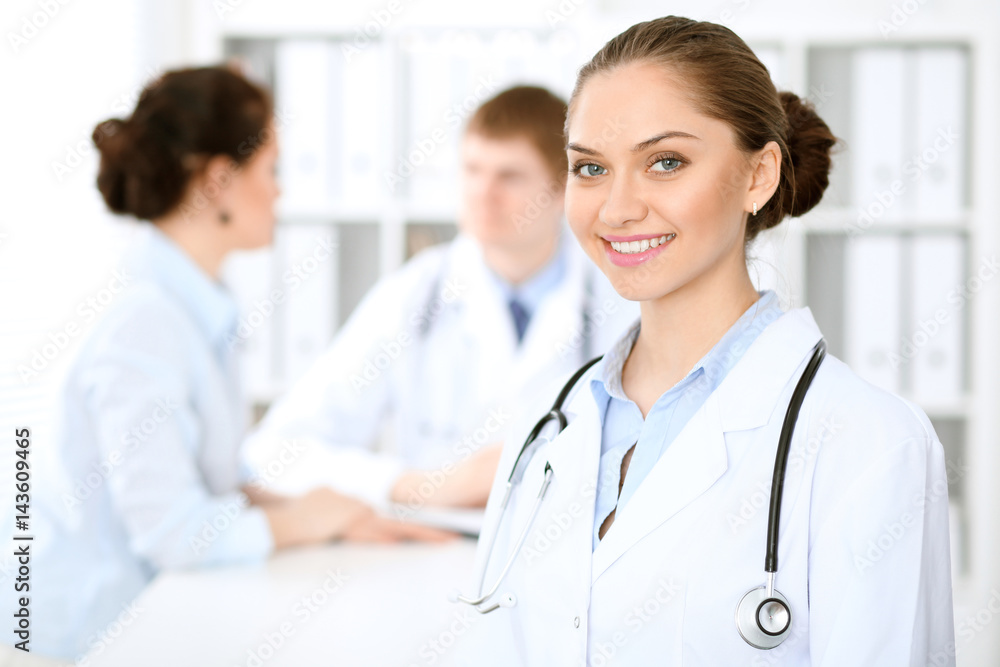 Happy doctor woman with medical staff at the hospital sitting at the table and discussing medical history Happy doctor woman with medical staff at the hospital sitting at the table and discussing medical history