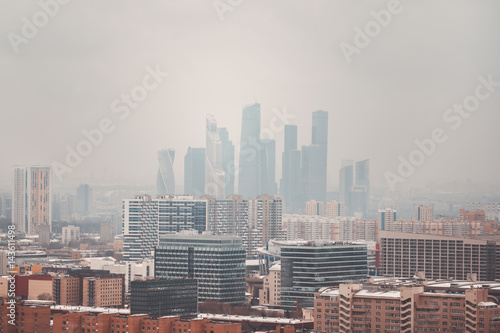 Close-up winter view from high point of futuristic modern contemporary skyscrapers and business area of metropolitan on early misty morning with residential district in foreground  Moscow city  Russia