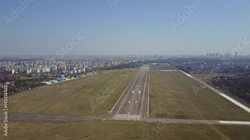 Propeller airplane taking off from airport runway on a sunny day, aerial shot