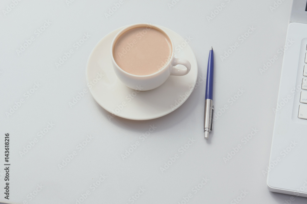 A cup of coffee, paper and a pen on a laptop A cup of coffee, paper and a pen on a laptop