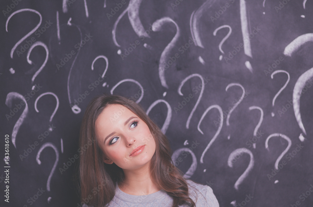 Young girl with question mark on a gray background Young girl with question mark on a gray background