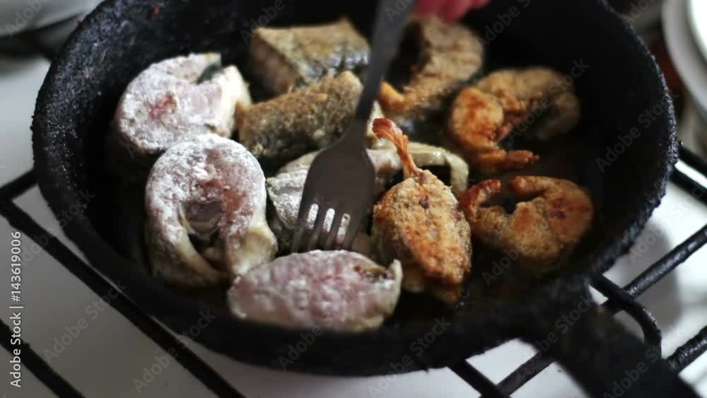 Fish fried in a pan turned with a fork time-lapse. Fish fried in a pan turned with a fork time-lapse.