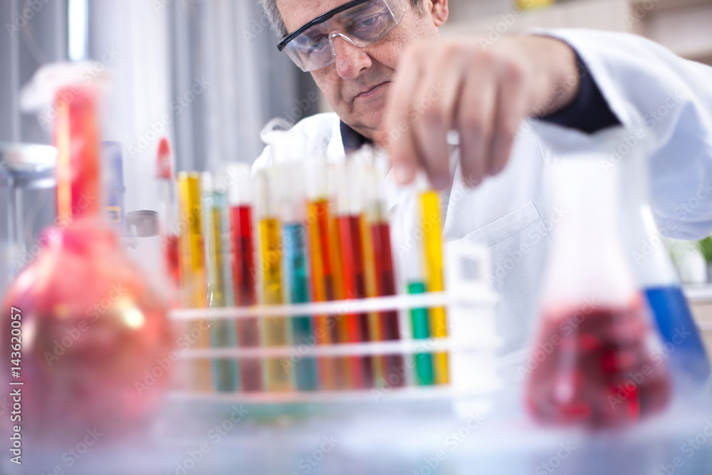 senior scientist with protective glasess researching in laboratory