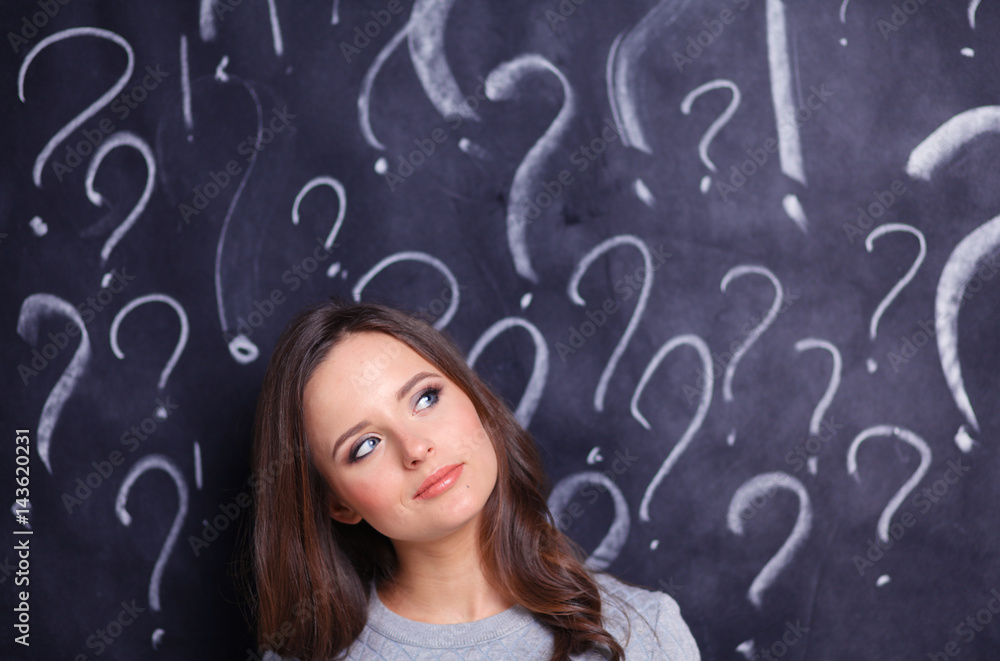 Young girl with question mark on a gray background Young girl with question mark on a gray background