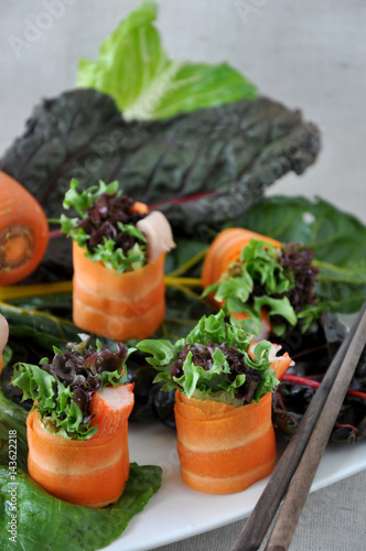 Carrot Rolls with Green Veggie on Background
