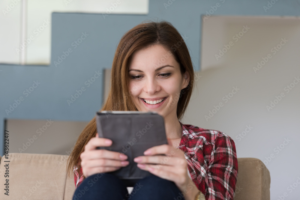 woman sitting on sofa with tablet computer woman sitting on sofa with tablet computer