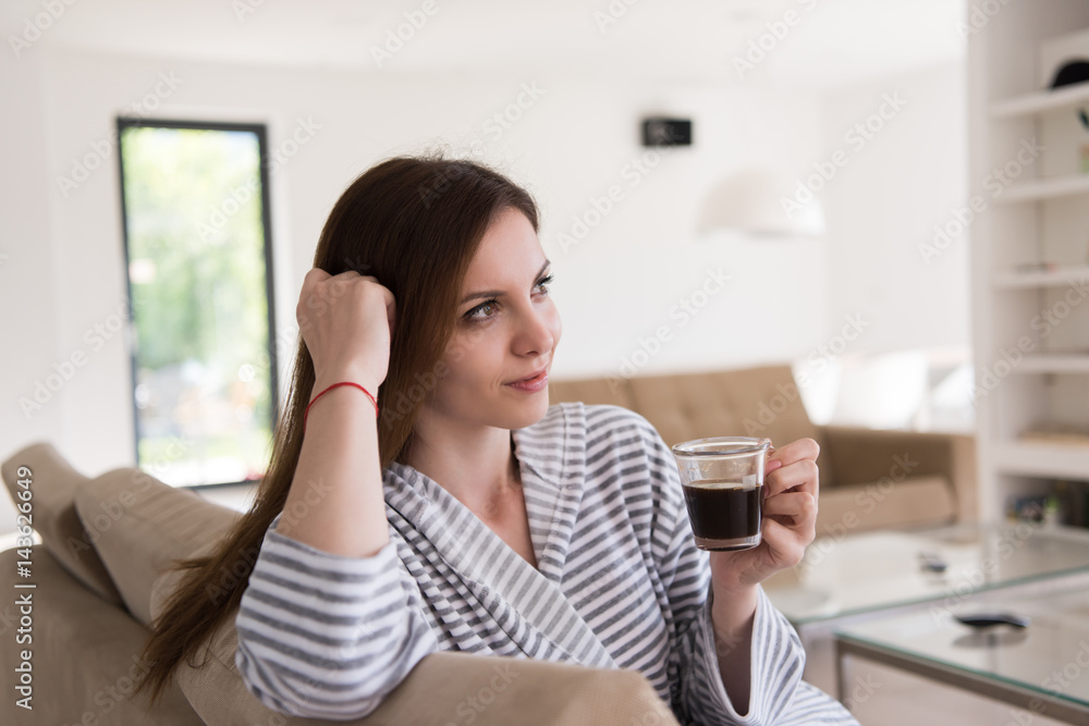 young woman in a bathrobe enjoying morning coffee young woman in a bathrobe enjoying morning coffee