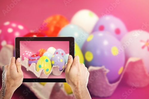 Composite image of cropped hand holding digital tablet