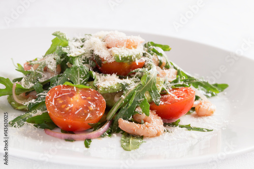 salad of fresh vegetables with prawns dressed with olive oil and balsamic vinegar and sprinkled with grated cheese