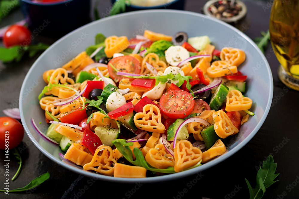 Pasta in the shape heart salad with tomatoes, cucumbers, olives, mozzarella and red onion Greek style. Pasta in the shape heart salad with tomatoes, cucumbers, olives, mozzarella and red onion Greek style.