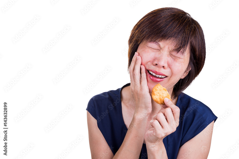 Asian women with intense toothache pain after biting cookie Asian women with intense toothache pain after biting cookie