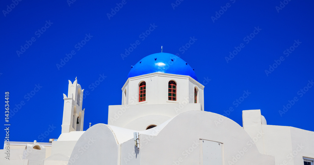 White church with blue dome in Santorini, Greece
