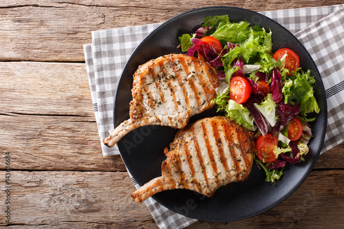Cuadro en lienzo BBQ spicy pork cutlet with mixed salad on a plate close-up