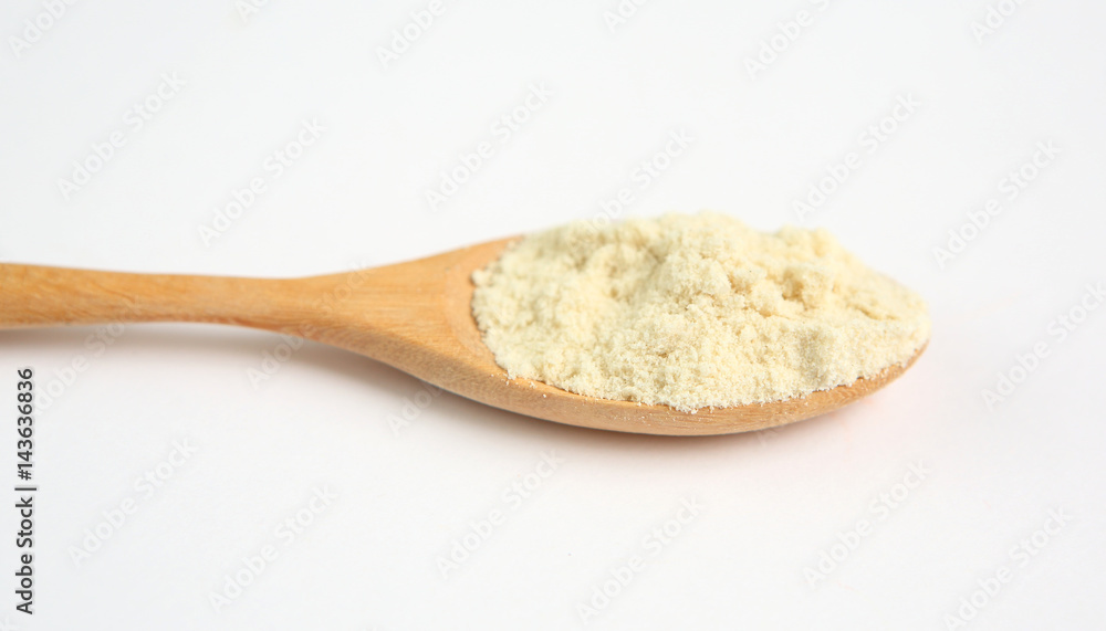 Full Powdered milk in wooden spoon over white background Full Powdered milk in wooden spoon over white background