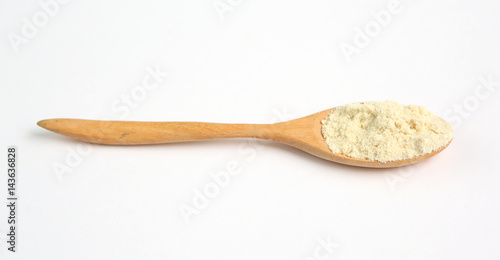 Full Powdered milk in wooden spoon over white background