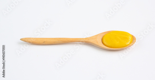 Vegetarian pumpkin soup in wooden spoon over white background