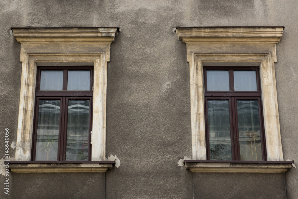 Two windows on the facade of the greyj old house