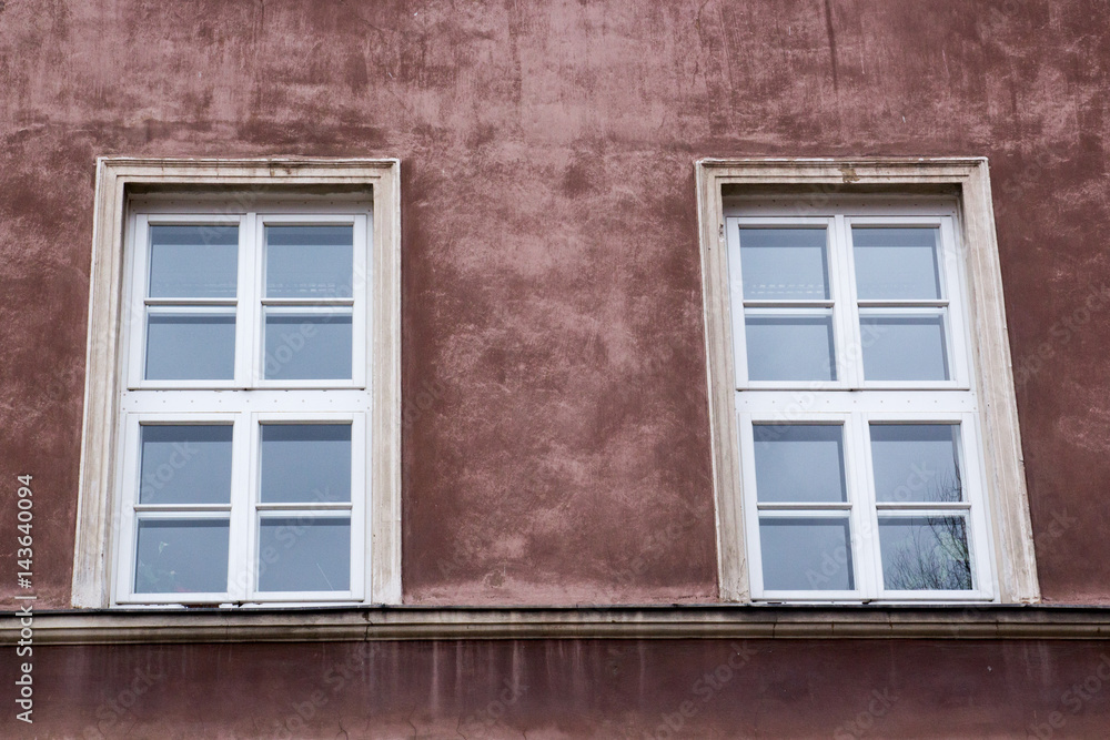 Two windows on the facade of the red old house Two windows on the facade of the red old house