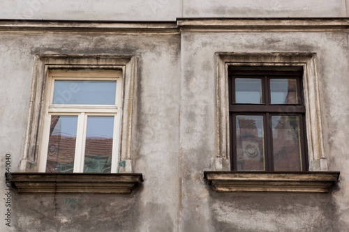 Two windows on the facade of the greyj old house © Bogdan