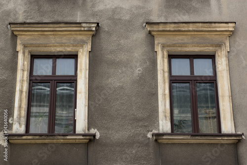 Two windows on the facade of the greyj old house