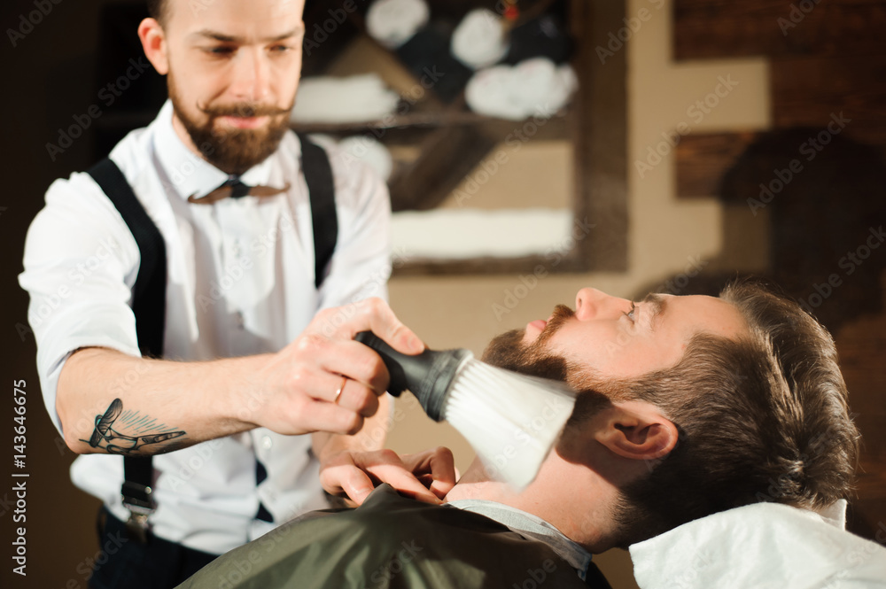 Master cuts hair and beard of men in the barbershop Master cuts hair and beard of men in the barbershop