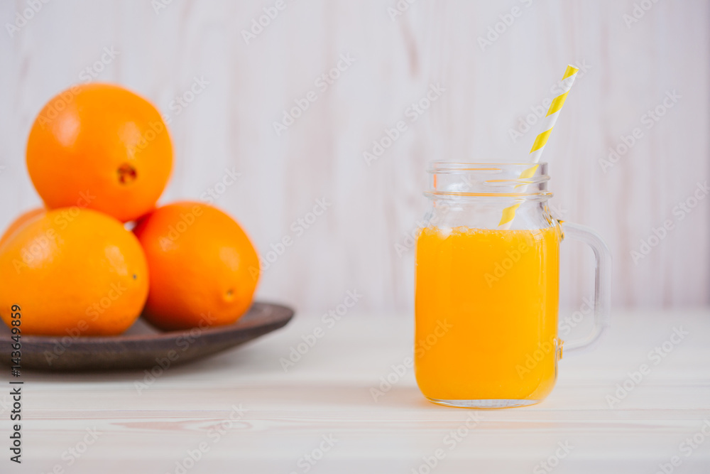 Fresh orange juice in a mason jar and orange sliced ripe on wooden table. Healthy eating concept. Fresh orange juice in a mason jar and orange sliced ripe on wooden table. Healthy eating concept.