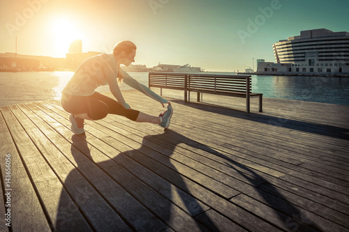 Photography Woman do exercise after running on the wooden pier under sunligh