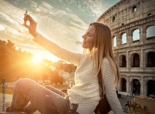 Photography Woman tourist selfie with phone camera in hands near the Coliseu
