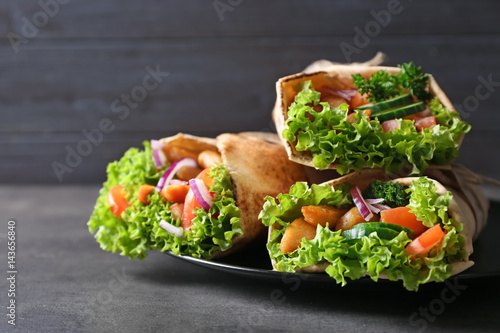 Plate with tasty kebab sandwiches on grey table