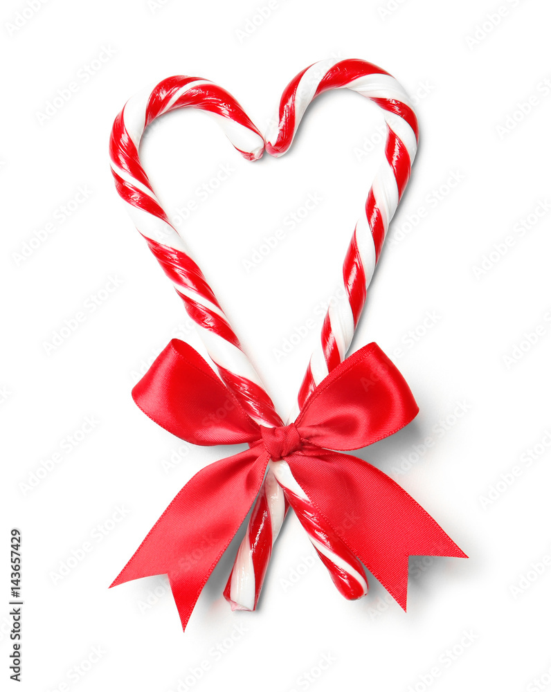 Heart shape made with candy canes on white background Heart shape made with candy canes on white background